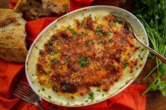 a plate of food with bread and parmesan cheese on the side next to it