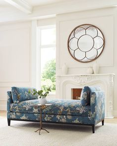 a living room filled with furniture and a large clock on the wall above it's fireplace