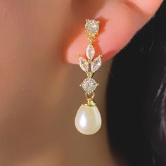 a close up of a pair of earrings on a woman's ear with pearls