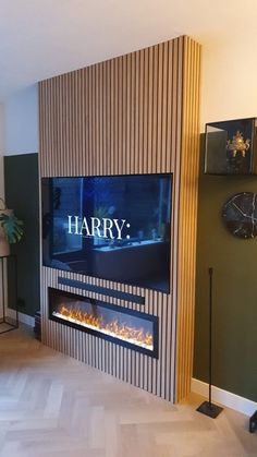 a living room with a large television mounted on the wall next to a fire place