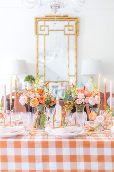 the table is set with flowers and candles