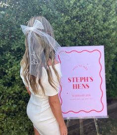 a woman with a veil on her head is standing in front of a sign that says steps hens