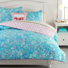 a bed with blue and pink comforters in a bedroom