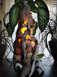 a sculpture made out of rocks and leaves on a table next to a potted plant