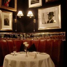 a table with white cloth and two framed pictures on the wall