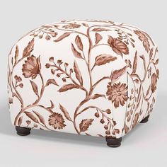 a white and brown ottoman with flowers on it