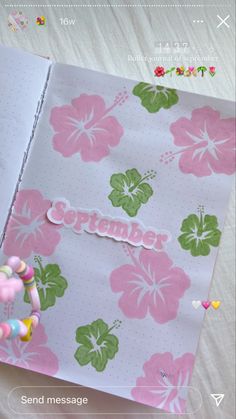 an open notebook with flowers on it and the word september written in cursive writing