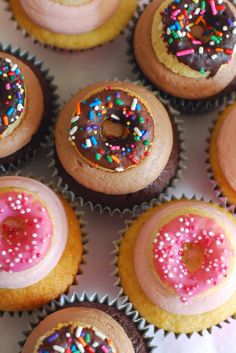 cupcakes with pink frosting and sprinkles are arranged in rows