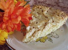 a piece of pie sitting on top of a white plate next to a bouquet of flowers