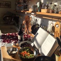 an open book sitting on top of a table next to bowls and utensils