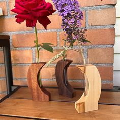 two wooden vases with flowers in them on a table