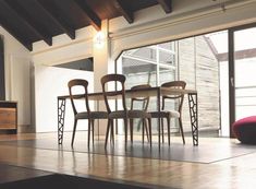 a dining room table and chairs in front of a large window