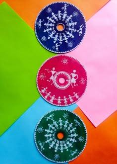 three brightly colored paper plates with designs on them sitting next to each other in different colors