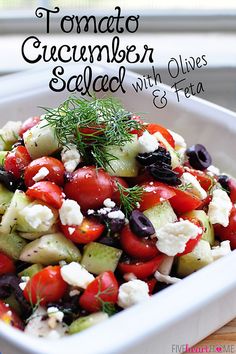 tomato cucumber salad with olives and feta in a white serving dish