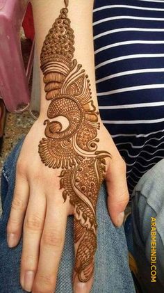 a woman's hand with henna tattoos on her left arm and the top half of