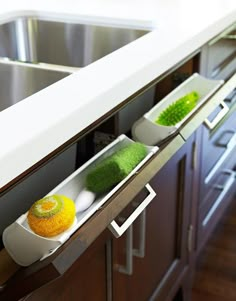 two trays with different types of food in them sitting on the edge of a kitchen counter