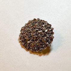 A sparkling and charming vintage rhinestone domed brooch with floral detail, circa 1960s-70s. The pin is about 1 1/2 inches in diameter.  Goldtone metal with delicate detail and openwork.  Little clear rhinestones.  Domed design.  C clasp with rollover safety.  Good vintage condition.  Some wear and darkening to the metal.   You can find more vintage pins here: https://www.etsy.com/shop/OtterCatHaus?section_id=17082336&ref=shopsection_leftnav_2 Please convo with any questions. I combine shipping and refund overages of more than fifty cents. Thanks for stopping by! Gold Flower-shaped Brooch With Rhinestones, Gold Flower-shaped Rhinestone Brooches, Gold Flower-shaped Brooches With Rhinestones, Gold Flower Brooches With Rhinestones, Rose Gold Flower Brooch For Party, Rose Gold Flower Brooches For Party, Rhinestone Flower, Rhinestone Brooches, Delicate Details