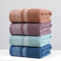 towels stacked on top of each other in various colors and patterns, all folded up