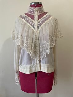 a woman's blouse on a mannequin with white lace and pink skirt