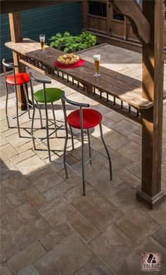 an outdoor table with four stools and some food on it