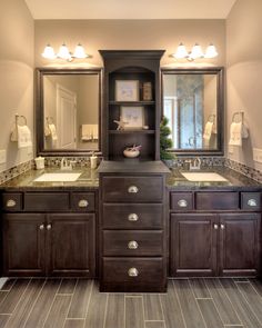 a bathroom with double sinks and two mirrors