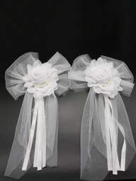 two white flowers are tied to organ bags