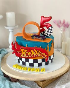 a birthday cake that is shaped like a race car with flames on the front and sides