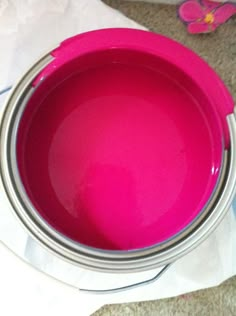 a pink bowl sitting on top of a white paper towel next to a canister