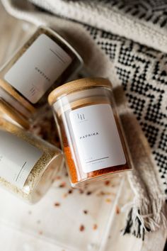 three candles sitting next to each other on top of a white cloth covered tablecloth