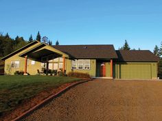 a green house sitting on top of a dirt road