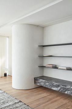 a room with some shelves and a rug on the floor