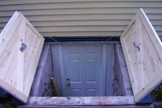 two doors are opened to reveal a room in the ground that has been built into the side of a house