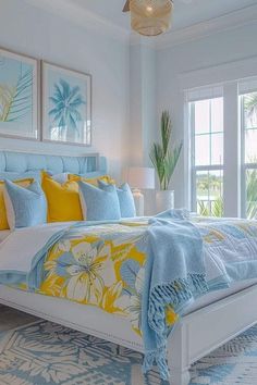 a bed with yellow and blue pillows in a bedroom next to two large pictures on the wall