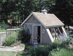 a small shed sitting in the middle of a garden