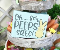 a sign that says oh for peeps sake with some eggs and carrots in the background