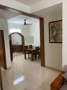 an open living room and dining area with tile flooring, white walls and wood trimming