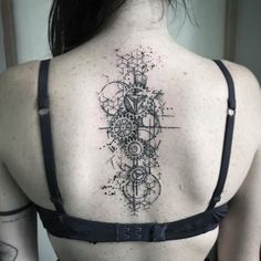 the back of a woman's shoulder with an intricate tattoo