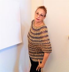 an older woman standing in front of a white wall