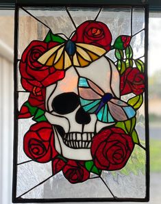 a stained glass window with a skull and roses