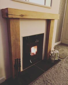 a fireplace with a mirror above it in a room that has carpet on the floor