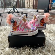 a pair of white shoes with pink bows and moan's name on the side