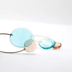 two different colored glasses sitting next to each other on a white surface, one with blue and the other pink