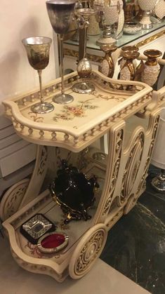 an antique vanity with two goblets on it and other items in the background