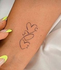 a woman's arm with a small tattoo on the left side of her arm