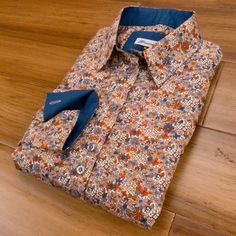 Shades of beige, blue, grey and tan brown aren't the typical colours for a floral shirt, but they do look great. Contrasted with blue inside the cuffs, collar and trimming along the button placket and finished with grey buttons. Made in a long sleeve relaxed fit style; no darting, but a slight taper to the waist, which has been popular with Grenouille customers for decades! Details: - 100% Cotton Poplin - Standard square shirt cuffs - Double back yoke - Relaxed Fit - a very slight shape to the b Brown Floral Print Shirt For Spring, Spring Floral Print Brown Shirt, Spring Brown Floral Print Shirt, Fitted Brown Printed Shirt, Printed Brown Shirt For Fall, Square Shirt, Shirt Cuff, Shades Of Beige, Fit Style