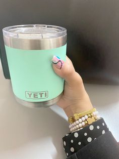 a woman's hand holding a yeti cup