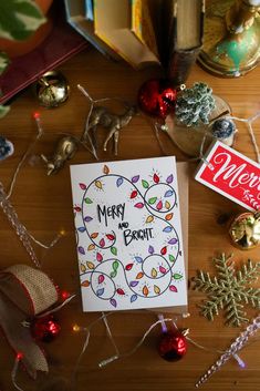 a christmas card sitting on top of a wooden table next to ornaments and other holiday decorations