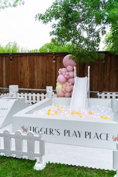 a giant inflatable slide with pink and yellow balloons sitting on top of it