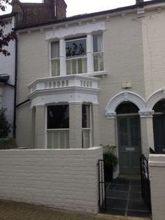 a white brick house with an arched window