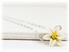 A minimalist style is featured with this petite white Easter Lily necklace for an everyday simple flower necklace. Choose your chain length as a choker necklace or longer. The tiny Easter Lily necklace flower measures approximately 12mm and is available in white or pink and on a choice of silver-plated, gold-plated, antique brass, 925 sterling silver or 14k gold filled components. Perfect for any occasion, formal or everyday wear. Flower size : approximately 12mm Components : Choose silver-plate White Adjustable Flower Charm Necklace, White Adjustable Charm Necklace With Flower Charm, White Sterling Silver Charm Necklace With Flower, White Sterling Silver Charm Necklaces With Flower Charm, White Flower Pendant Charm Necklace With Delicate Chain, Delicate White Flower Charm Necklaces, Delicate White Flower Charm Necklace, Dainty White Necklace With Flower Charm, White Flower Necklace With Adjustable Chain